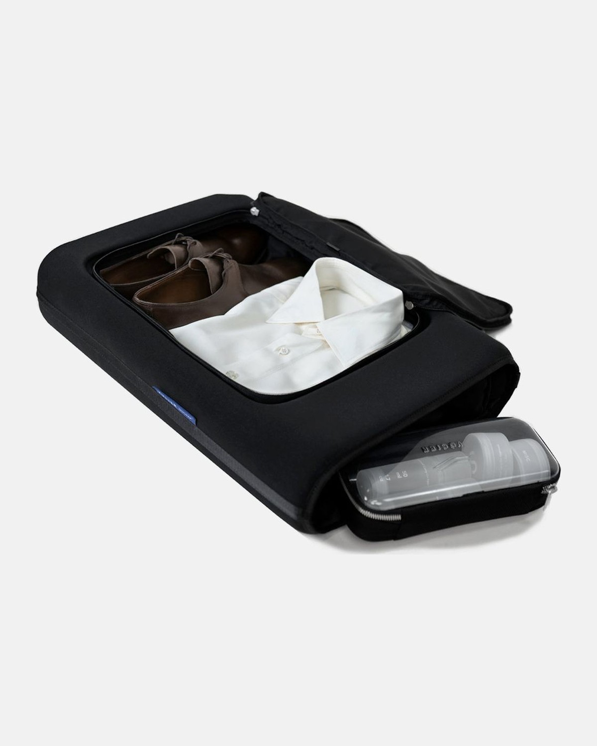 Open VOCIER carry-on packed with a suit, shirts and shoes around the Zero Crease core